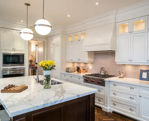 Kitchen remodel with marble countertops, pendant lights and custom cabinetry